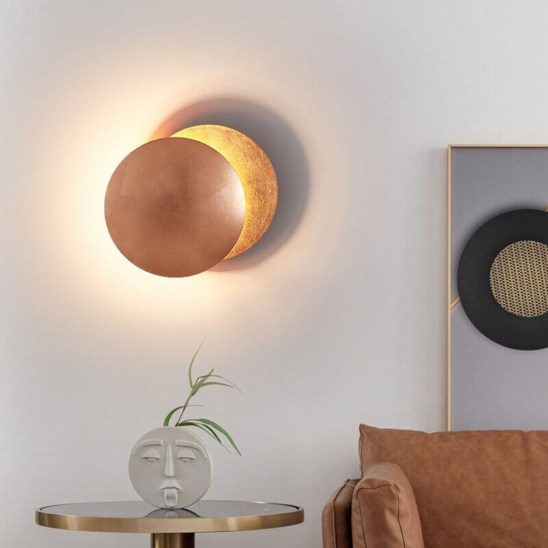 Goldene Wandleuchte mit Sonnenfinsternis-Effekt