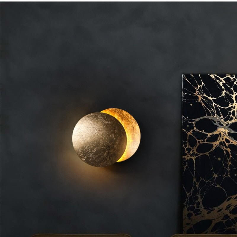Goldene Wandleuchte mit Sonnenfinsternis-Effekt