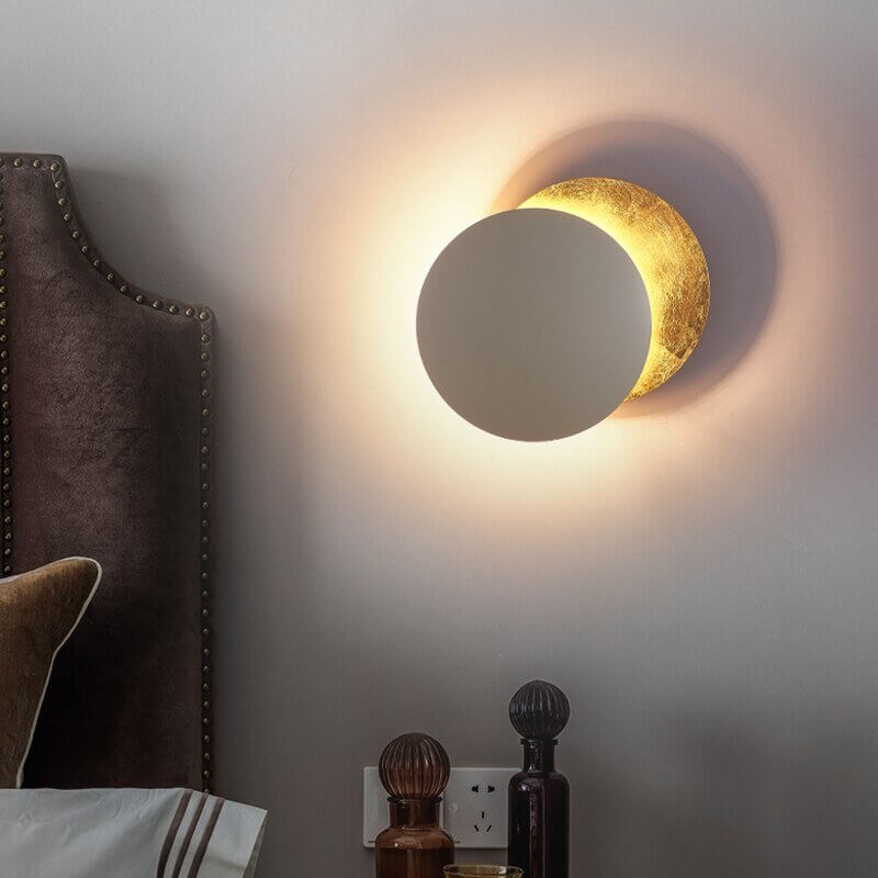 Goldene Wandleuchte mit Sonnenfinsternis-Effekt