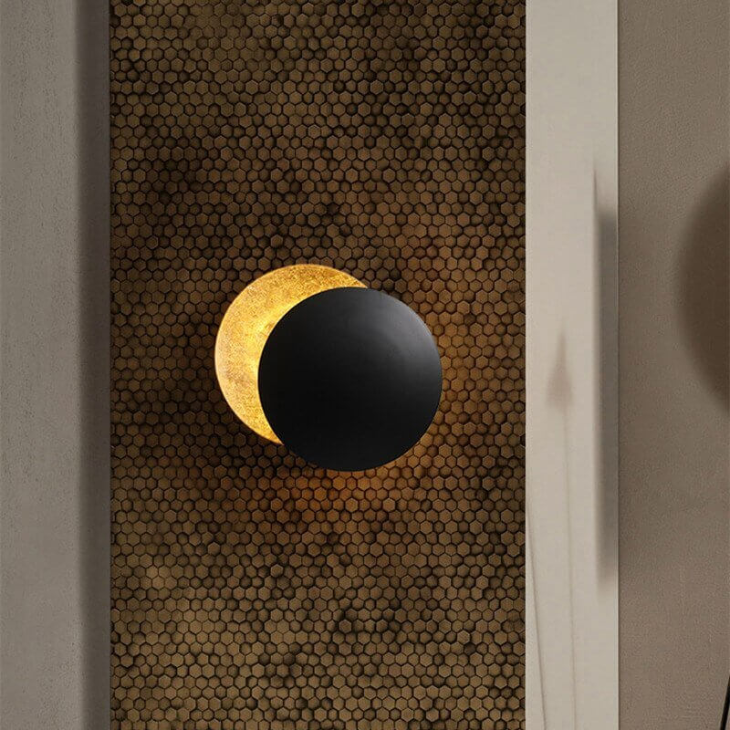 Goldene Wandleuchte mit Sonnenfinsternis-Effekt