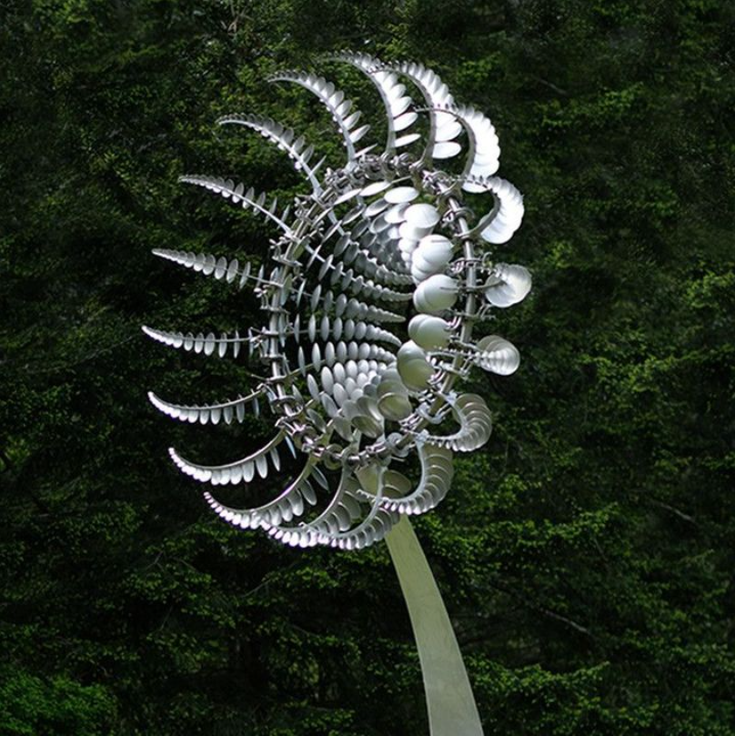 "Metallische Windmühle im Garten mit Zweiflügel-Technologie, sorgt für dynamischen visuellen Effekt und Atmosphäre."