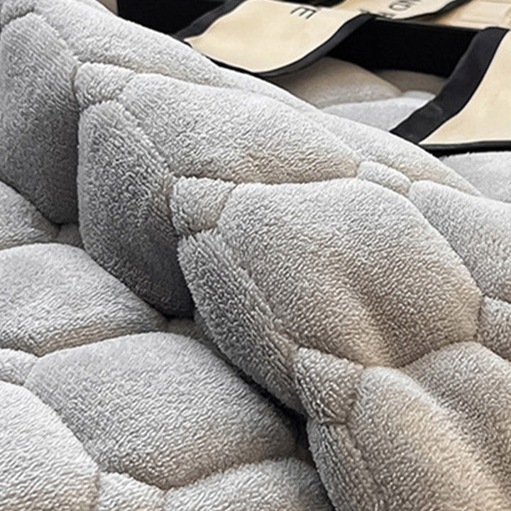 "Weiche Tagesdecke mit quadratischer Textur, flauschig und modern auf Sofa drapiert, verleiht stilvolle Gemütlichkeit."