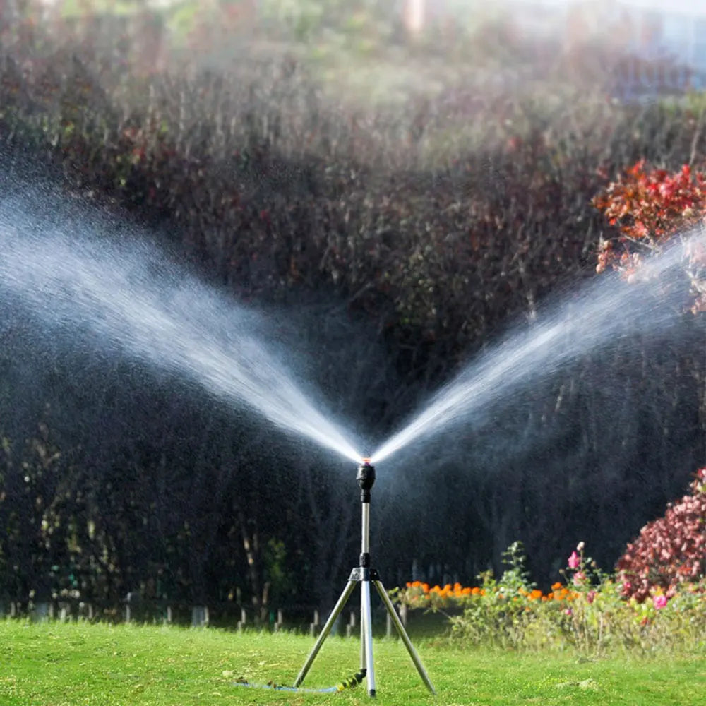 "Automatischer rotierender Gartensprinkler mit Stativ und flexiblem Sprühmechanismus im Garten platziert"