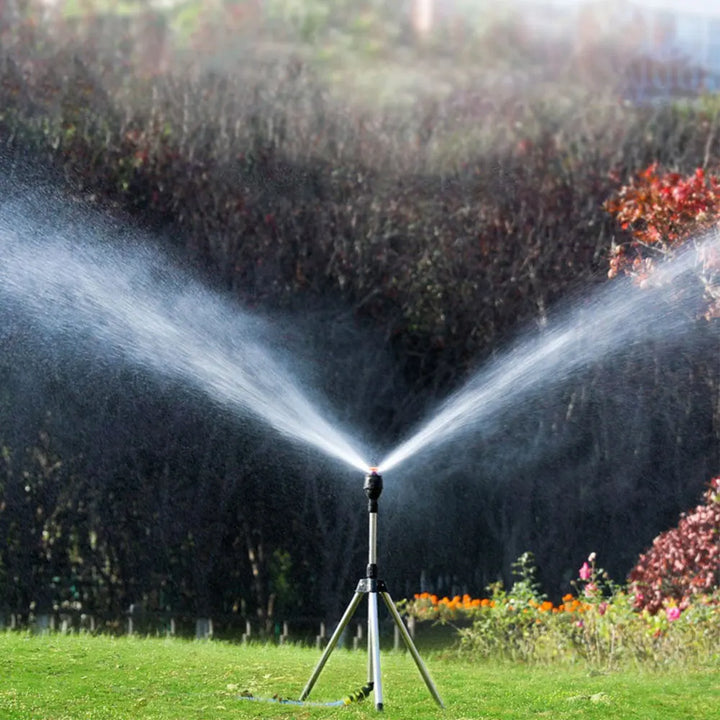 "Automatischer rotierender Gartensprinkler mit Stativ und flexiblem Sprühmechanismus im Garten platziert"
