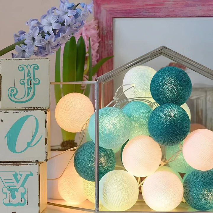 "Bunte LED Kugellichterkette mit Baumwollkugeln in verschiedenen Farben, schafft gemütliches Ambiente im Haus."