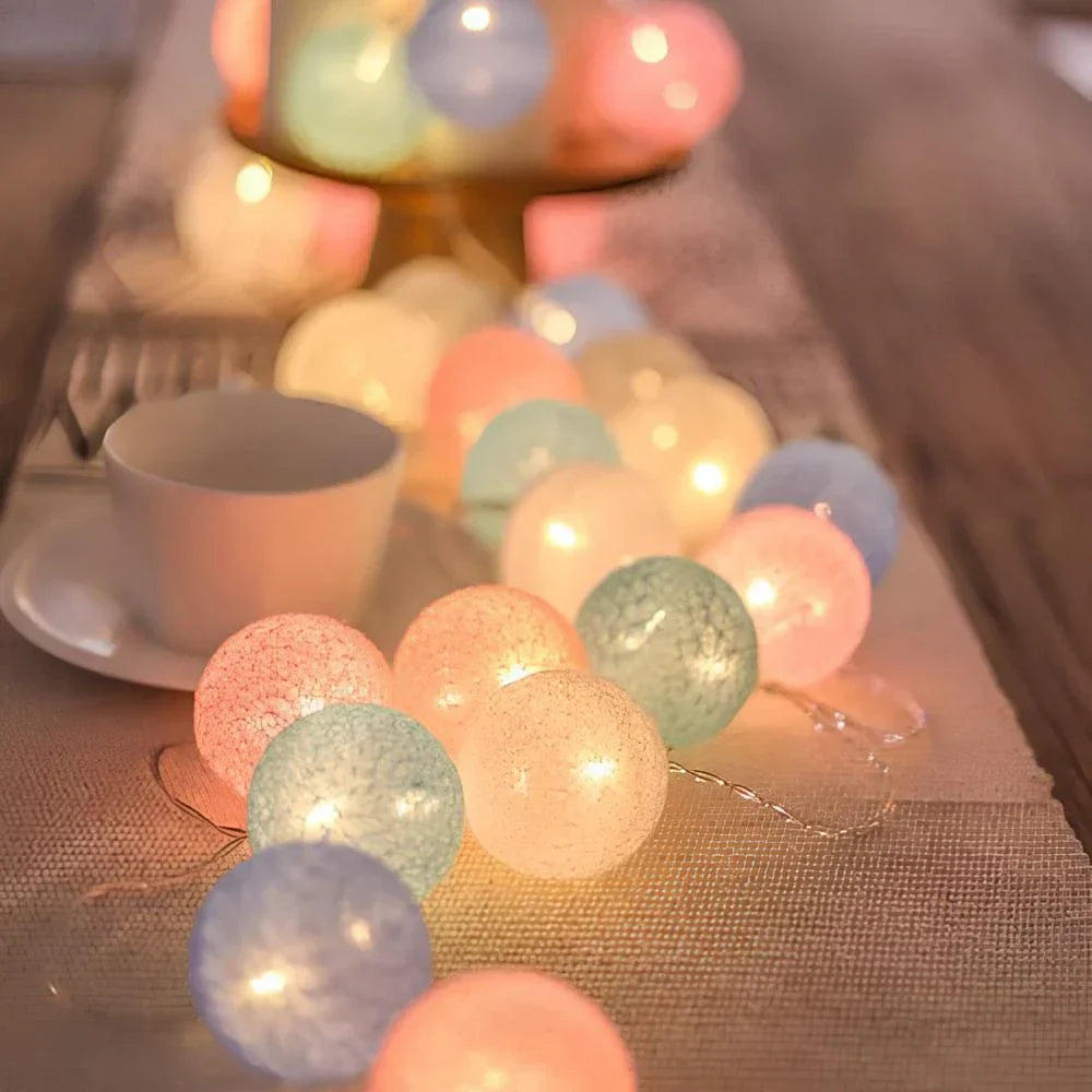 "Bunte LED Kugellichterkette mit Baumwollkugeln in verschiedenen Farben, schafft gemütliches Ambiente im Haus."