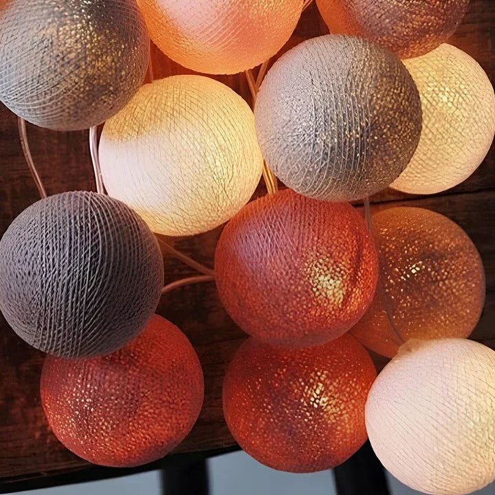 "Bunte LED Kugellichterkette mit Baumwollkugeln in verschiedenen Farben, schafft gemütliches Ambiente im Haus."