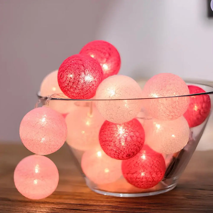 "Bunte LED Kugellichterkette mit Baumwollkugeln in verschiedenen Farben, schafft gemütliches Ambiente im Haus."