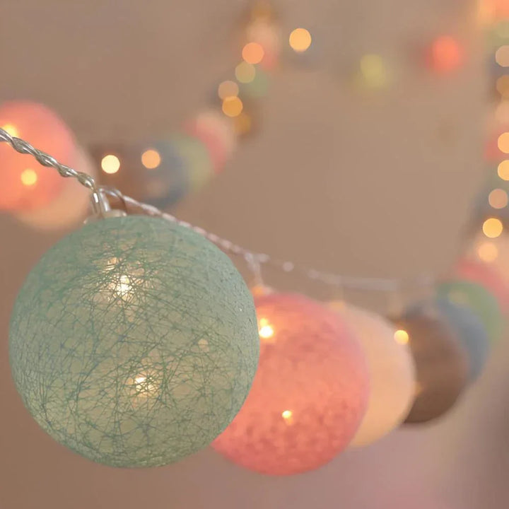 "Bunte LED Kugellichterkette mit Baumwollkugeln in verschiedenen Farben, schafft gemütliches Ambiente im Haus."