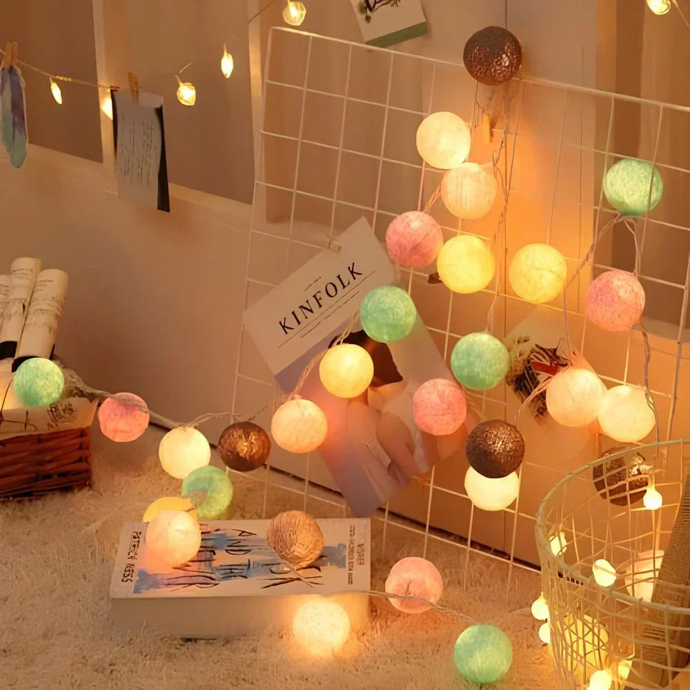 "Bunte LED Kugellichterkette mit Baumwollkugeln in verschiedenen Farben, schafft gemütliches Ambiente im Haus."