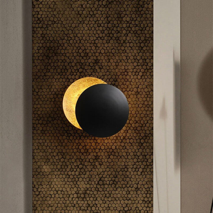 Goldene Wandleuchte mit Sonnenfinsternis-Effekt