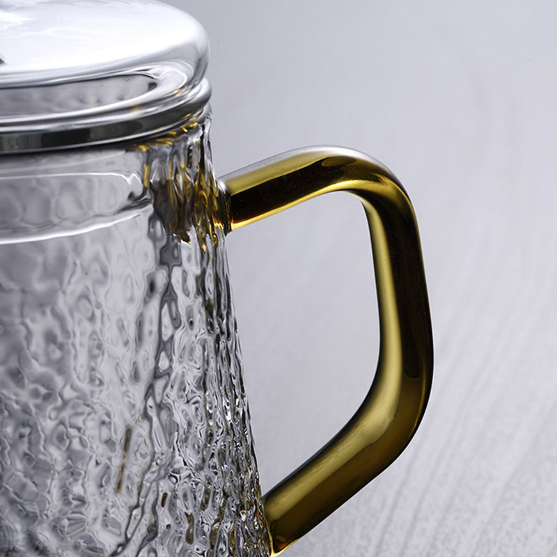 Elegante Teekanne aus gehämmertem, hitzebeständigem Glas mit integriertem Sieb und goldfarbenem Griff. Ideal für Teegenuss.