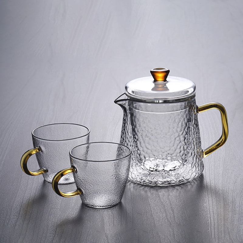 Elegante Teekanne aus gehämmertem, hitzebeständigem Glas mit integriertem Sieb und goldfarbenem Griff. Ideal für Teegenuss.