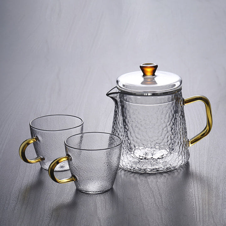 Elegante Teekanne aus gehämmertem, hitzebeständigem Glas mit integriertem Sieb und goldfarbenem Griff. Ideal für Teegenuss.