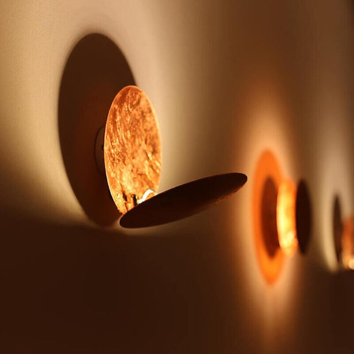 Goldene Wandleuchte mit Sonnenfinsternis-Effekt
