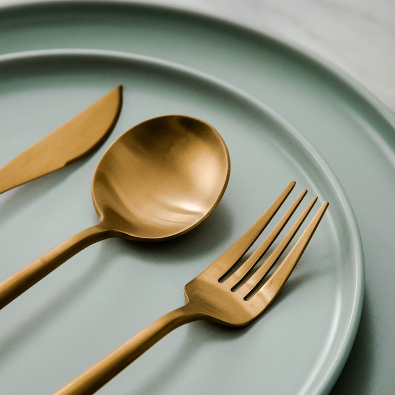 "Goldenes Edelstahl-Besteckset mit elegantem minimalistischen Design, ideal für moderne Tischdekorationen."