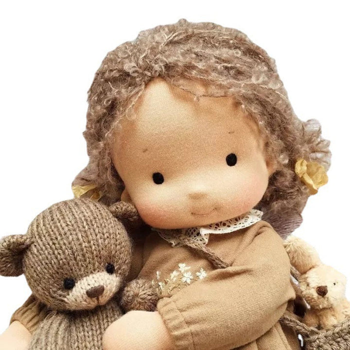 "Handgefertigte Waldorfpuppe in Erdtönen, mit rotem Haar, braunem Kleid und blauem Hut, sicher und natürlich."
