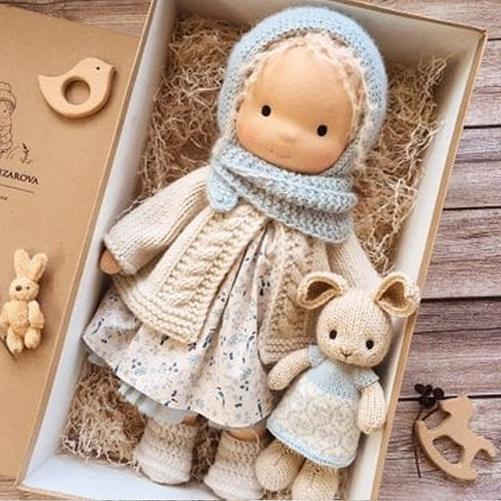 "Handgefertigte Waldorfpuppe in Erdtönen, mit rotem Haar, braunem Kleid und blauem Hut, sicher und natürlich."
