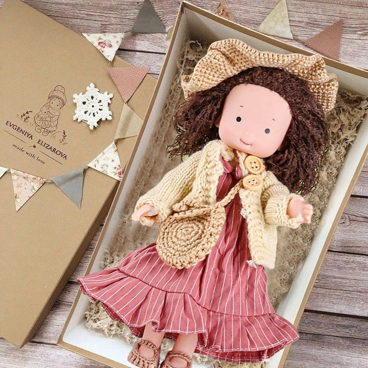 "Handgefertigte Waldorfpuppe in Erdtönen, mit rotem Haar, braunem Kleid und blauem Hut, sicher und natürlich."
