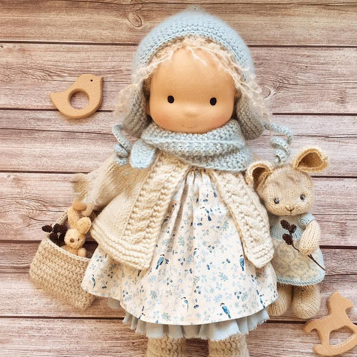 "Handgefertigte Waldorfpuppe in Erdtönen, mit rotem Haar, braunem Kleid und blauem Hut, sicher und natürlich."