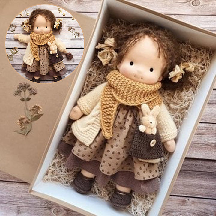 "Handgefertigte Waldorfpuppe in Erdtönen, mit rotem Haar, braunem Kleid und blauem Hut, sicher und natürlich."
