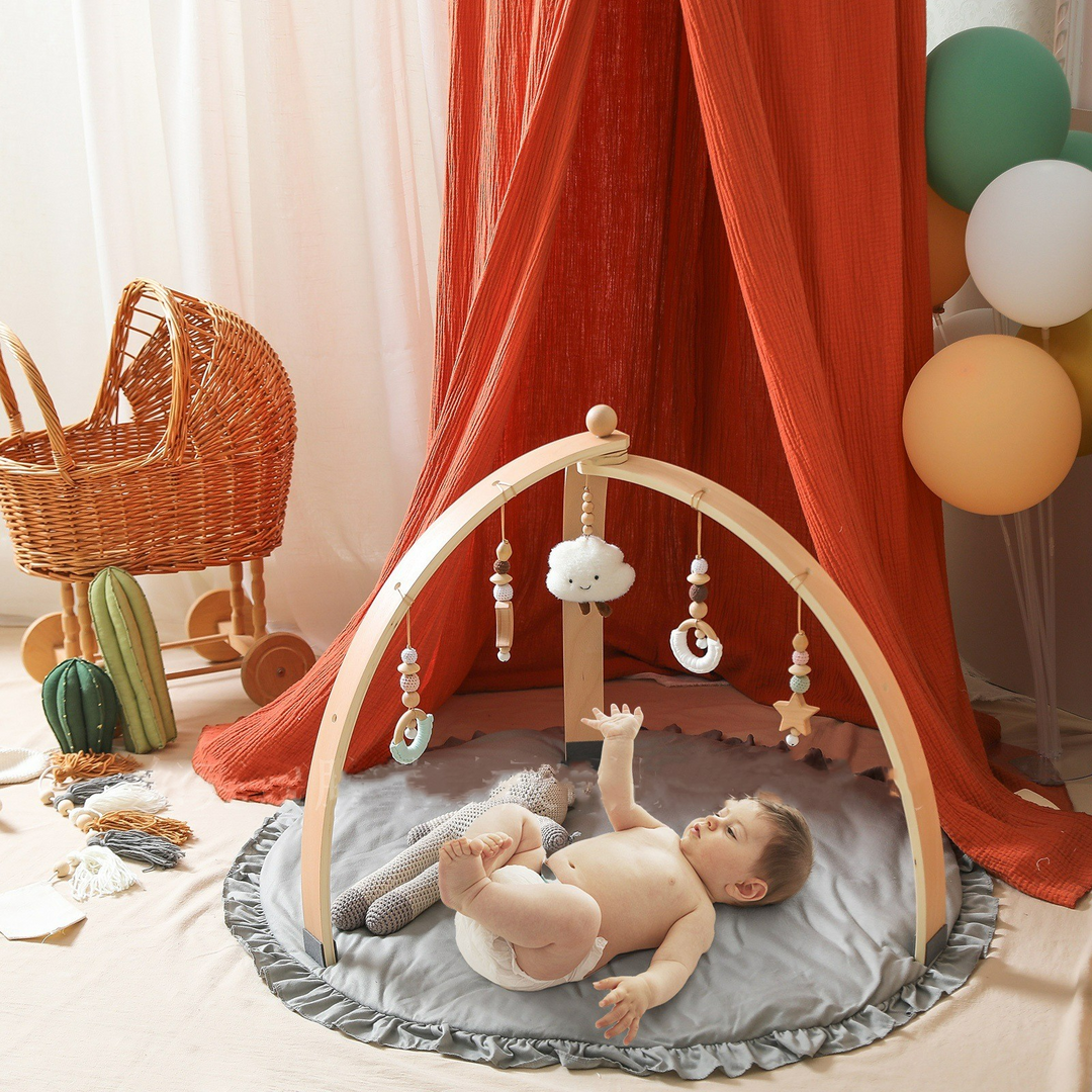 Holz-Aktivitätsbogen für Babys mit bunten Hängespielzeugen zur Förderung von Motorik und sensorischen Fähigkeiten.