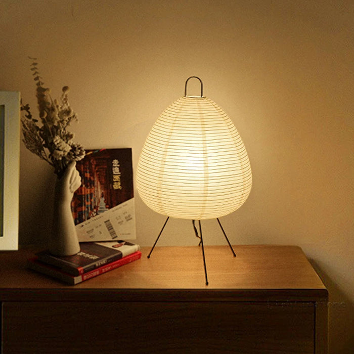 Japanische Tischlampe mit Reispapier, strahlt warmes, diffuses Licht aus, elegantes und zeitloses Design für Innenräume.