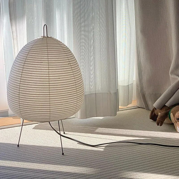 Japanische Tischlampe mit Reispapier, strahlt warmes, diffuses Licht aus, elegantes und zeitloses Design für Innenräume.