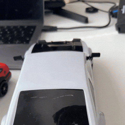 "RC-Driftauto mit Allradantrieb, driftend auf Straße, zeigt schnelle Kurvenfahrt, rote Karosserie, schwarzer Spoiler."
