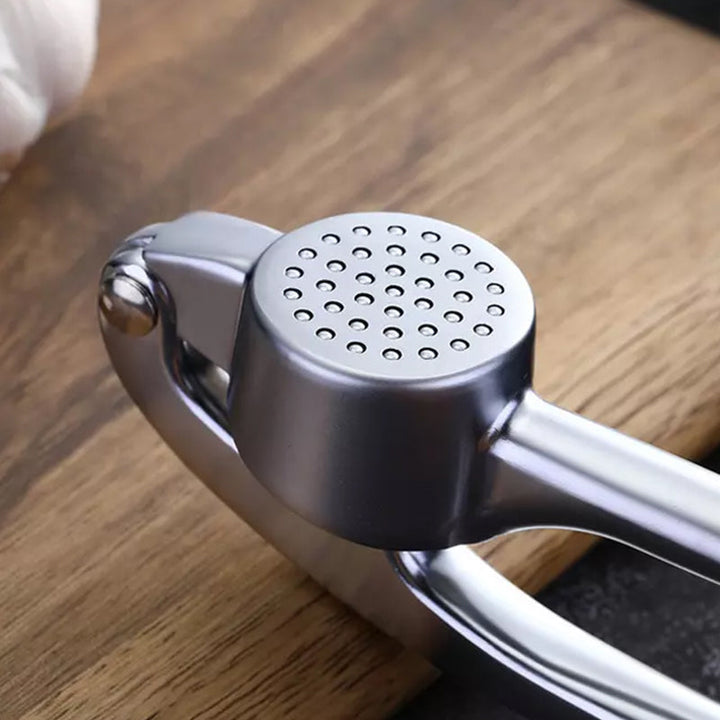 Robuste Edelstahl Knoblauchpresse mit ergonomischem Griff, große Kammer, ideal für Küche, einfache Reinigung.