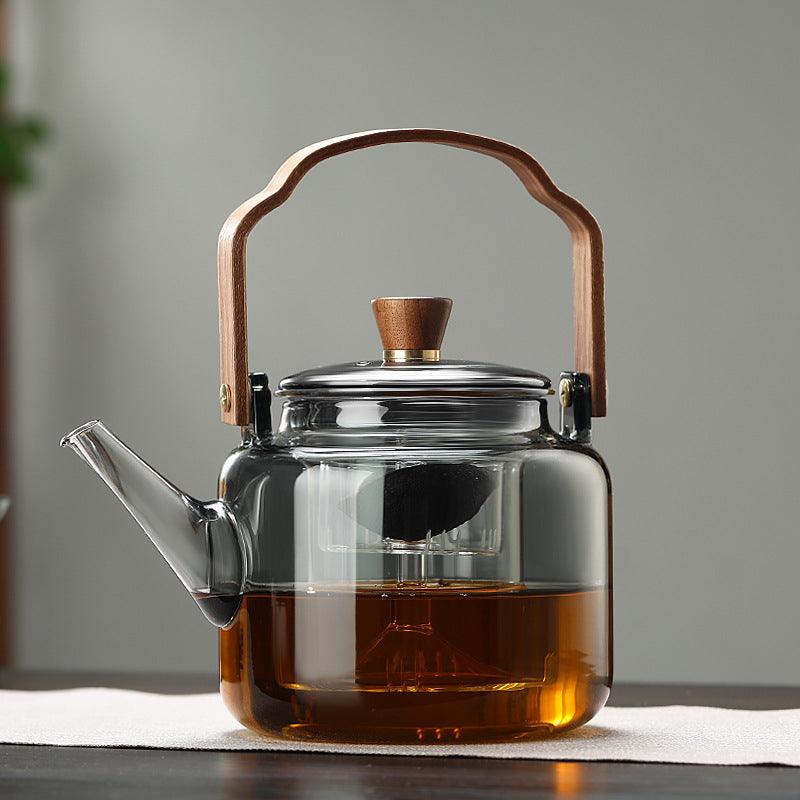 "Stilvolle Teekanne aus Glas und Holz mit elegantem Design und ergonomischem Griff, ideal für Teezeremonien."