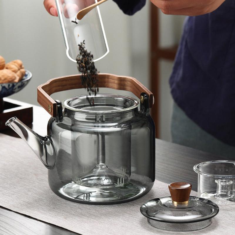 "Stilvolle Teekanne aus Glas und Holz mit elegantem Design und ergonomischem Griff, ideal für Teezeremonien."