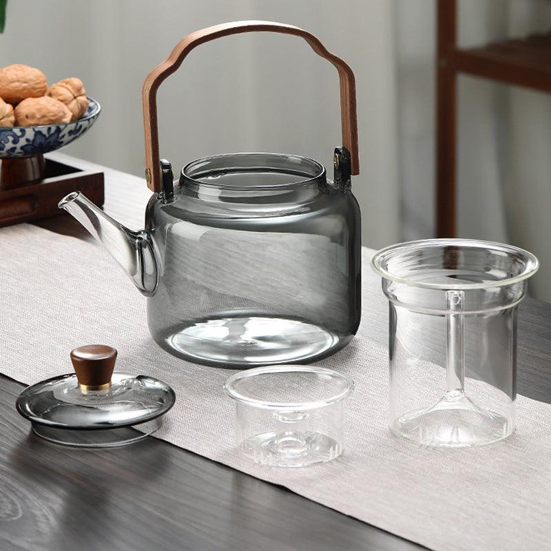 "Stilvolle Teekanne aus Glas und Holz mit elegantem Design und ergonomischem Griff, ideal für Teezeremonien."