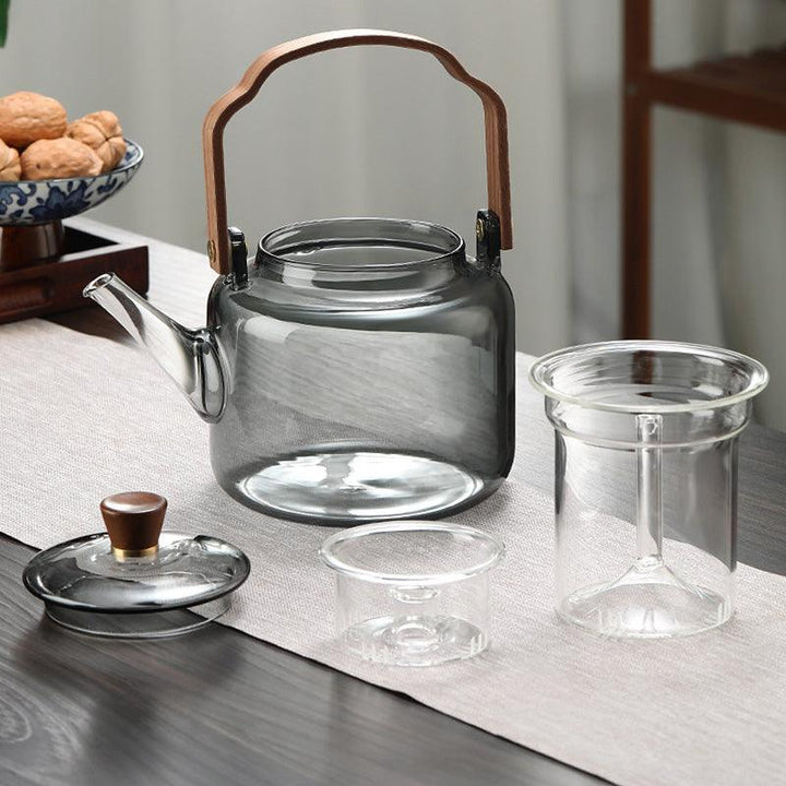 "Stilvolle Teekanne aus Glas und Holz mit elegantem Design und ergonomischem Griff, ideal für Teezeremonien."