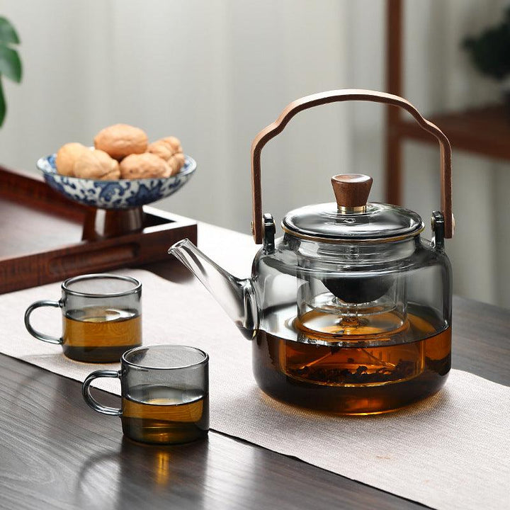 "Stilvolle Teekanne aus Glas und Holz mit elegantem Design und ergonomischem Griff, ideal für Teezeremonien."