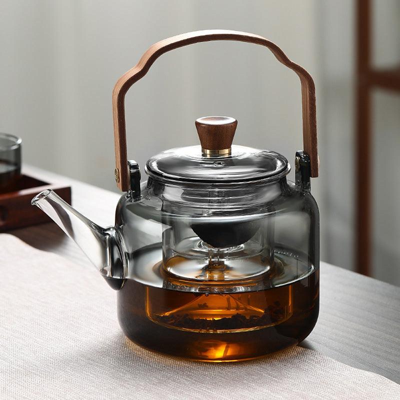 "Stilvolle Teekanne aus Glas und Holz mit elegantem Design und ergonomischem Griff, ideal für Teezeremonien."