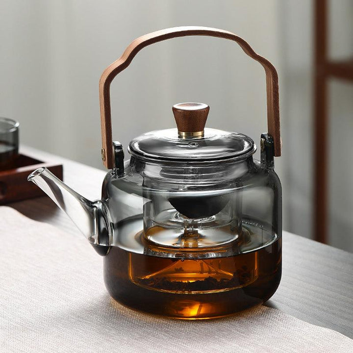 "Stilvolle Teekanne aus Glas und Holz mit elegantem Design und ergonomischem Griff, ideal für Teezeremonien."