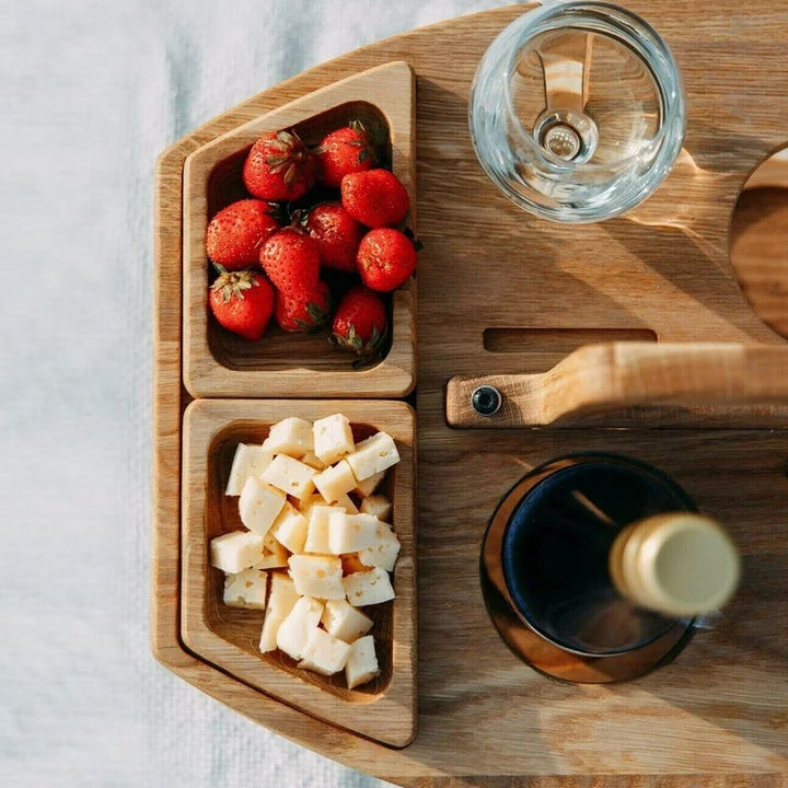 "Tragbarer Holz-Picknicktisch mit Glashalterungen, Snackfächern, kompakt zusammenklappbar für Weinausflüge."