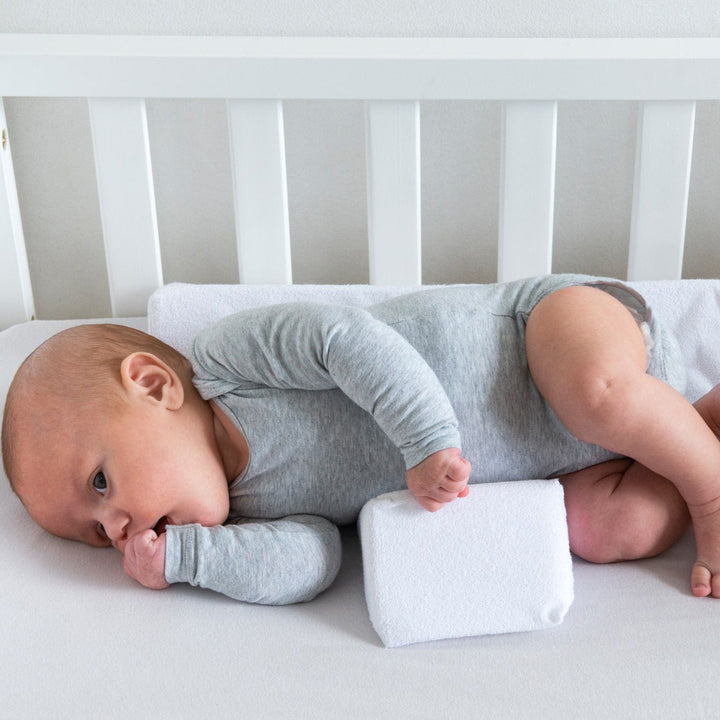 Verstellbares Baby Anti-Roll-Keilkissen, weiß, mit Klettverschlüssen; unterstützt sicheren Schlaf und verhindert Wegrollen.
