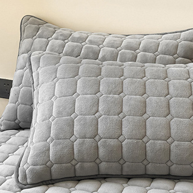 "Weiche Tagesdecke mit quadratischer Textur, flauschig und modern auf Sofa drapiert, verleiht stilvolle Gemütlichkeit."