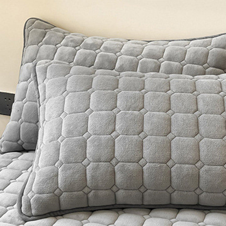 "Weiche Tagesdecke mit quadratischer Textur, flauschig und modern auf Sofa drapiert, verleiht stilvolle Gemütlichkeit."