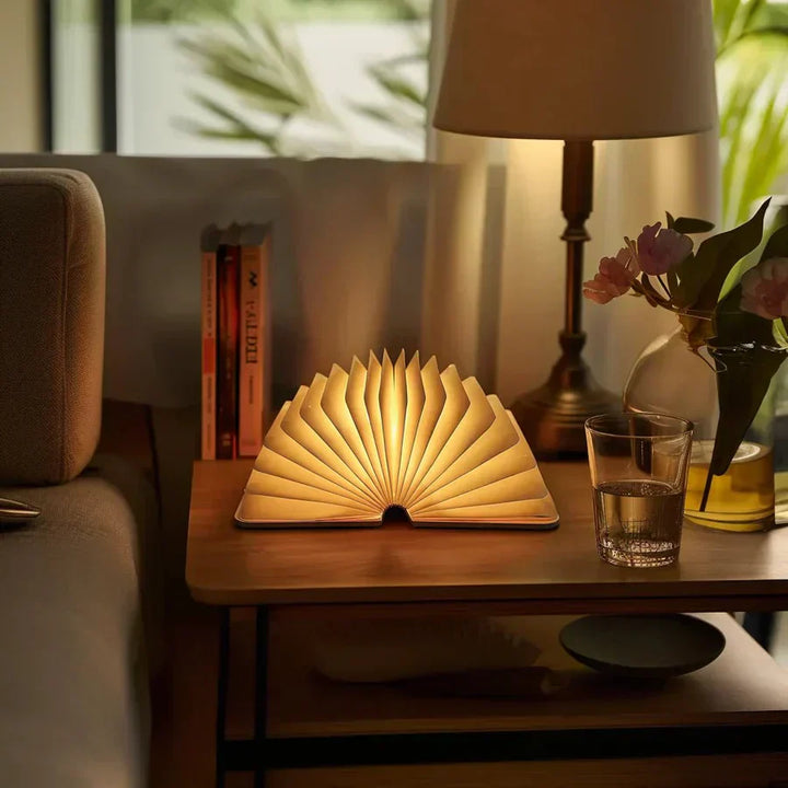 "Zusammenklappbare LED-Buchlampe in Holzoptik, entfaltet wie Märchenbuch, warmes Licht, ideal für Leselampen und Dekoration."
