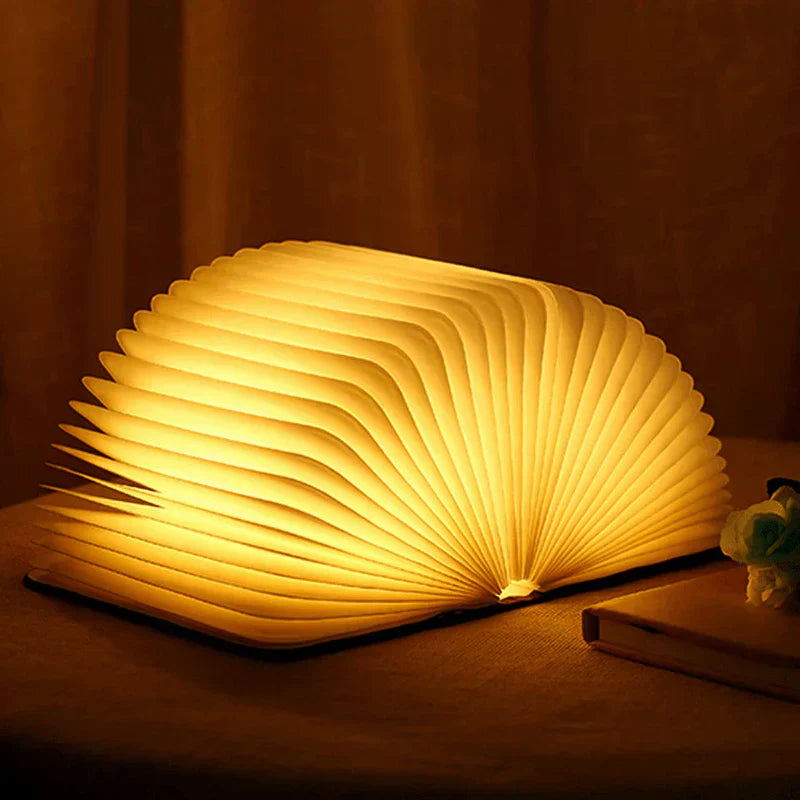 "Zusammenklappbare LED-Buchlampe in Holzoptik, entfaltet wie Märchenbuch, warmes Licht, ideal für Leselampen und Dekoration."