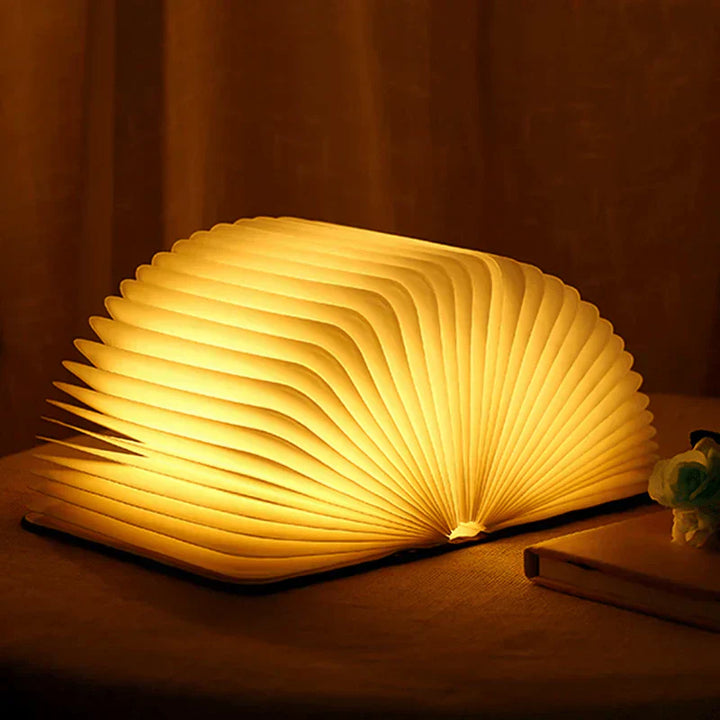 "Zusammenklappbare LED-Buchlampe in Holzoptik, entfaltet wie Märchenbuch, warmes Licht, ideal für Leselampen und Dekoration."