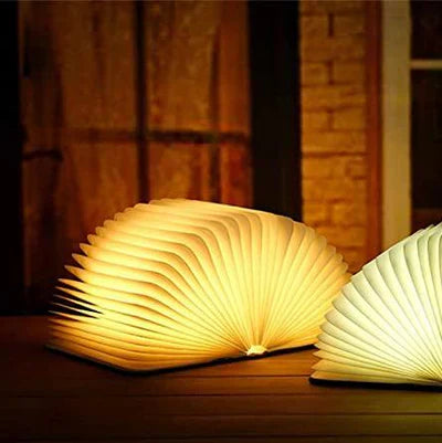 "Zusammenklappbare LED-Buchlampe in Holzoptik, entfaltet wie Märchenbuch, warmes Licht, ideal für Leselampen und Dekoration."