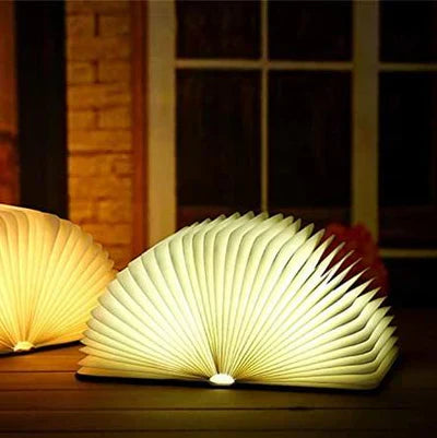 "Zusammenklappbare LED-Buchlampe in Holzoptik, entfaltet wie Märchenbuch, warmes Licht, ideal für Leselampen und Dekoration."