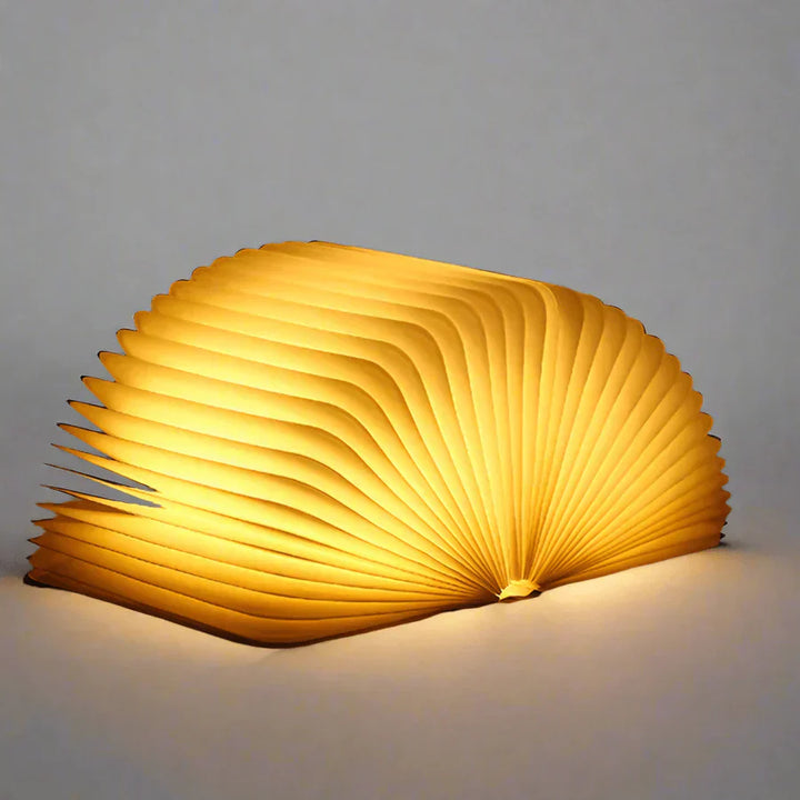 "Zusammenklappbare LED-Buchlampe in Holzoptik, entfaltet wie Märchenbuch, warmes Licht, ideal für Leselampen und Dekoration."